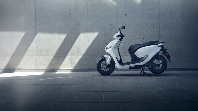 Scooter Honda CUV e garé dans un garage.
